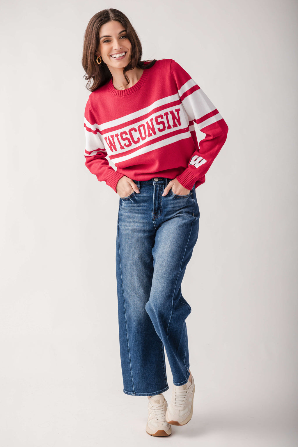 Red and white campus sweater with "Wisconsin" text stripe across chest, styled with blue jeans.