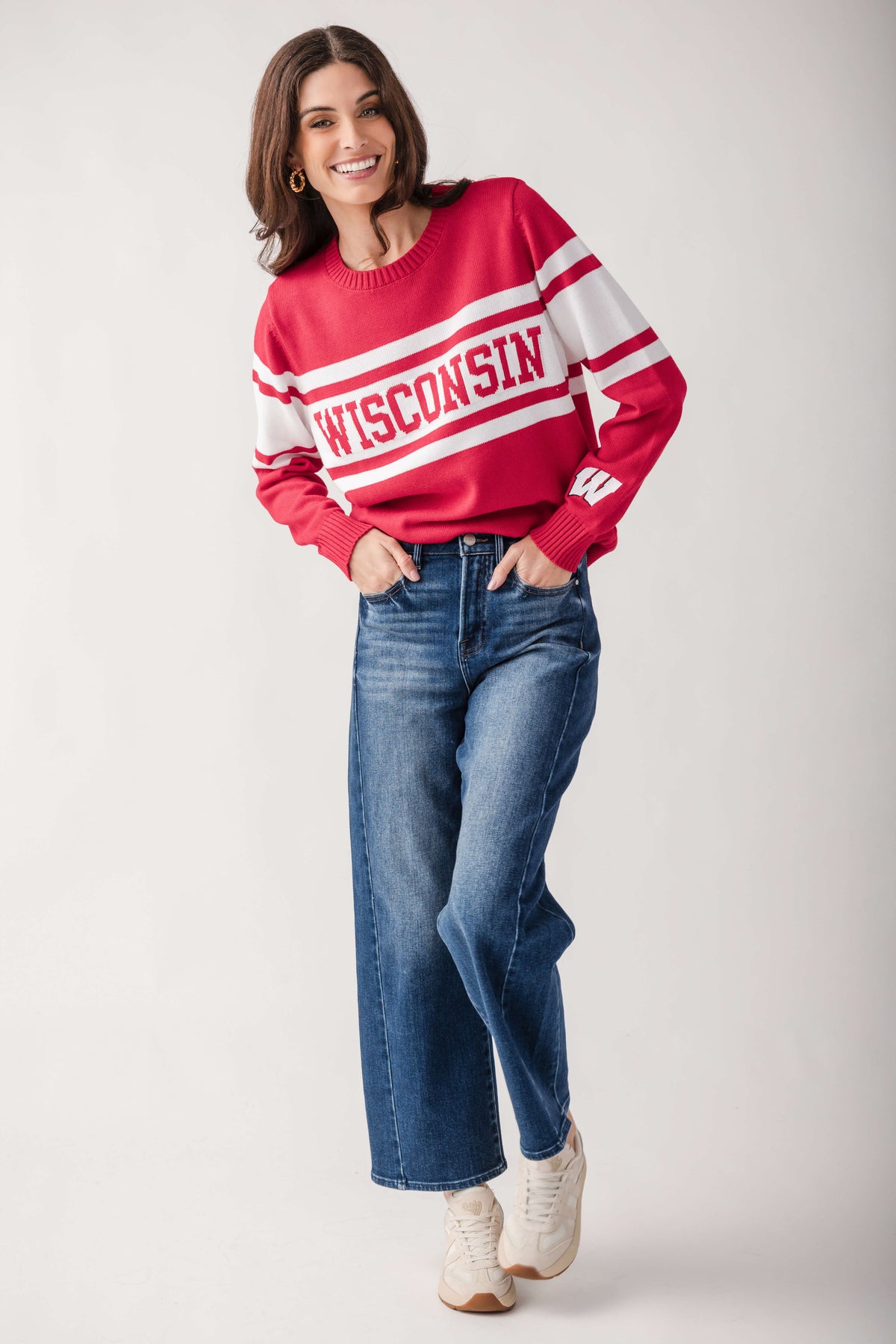 Red and white campus sweater with "Wisconsin" text stripe across chest, styled with blue jeans.