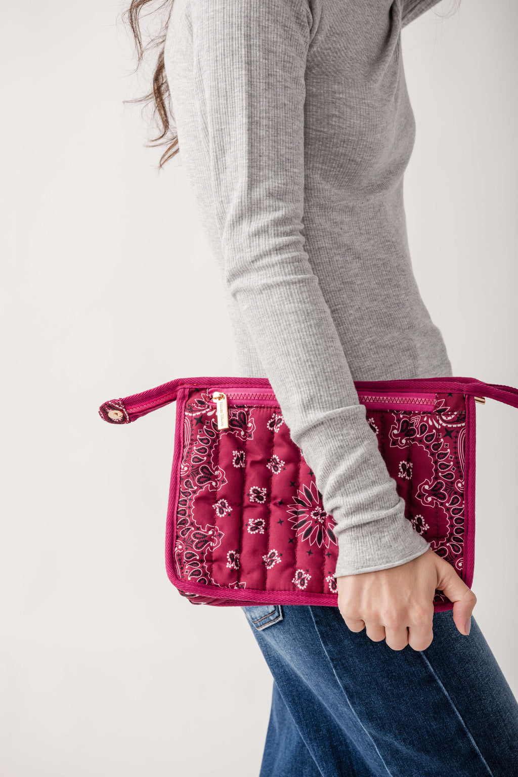 Fuchsia bandana pouch with white and red floral pattern, dual handles, worn at hip.