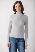 Light gray ribbed mock neck long-sleeve top with seamless construction worn with blue jeans.