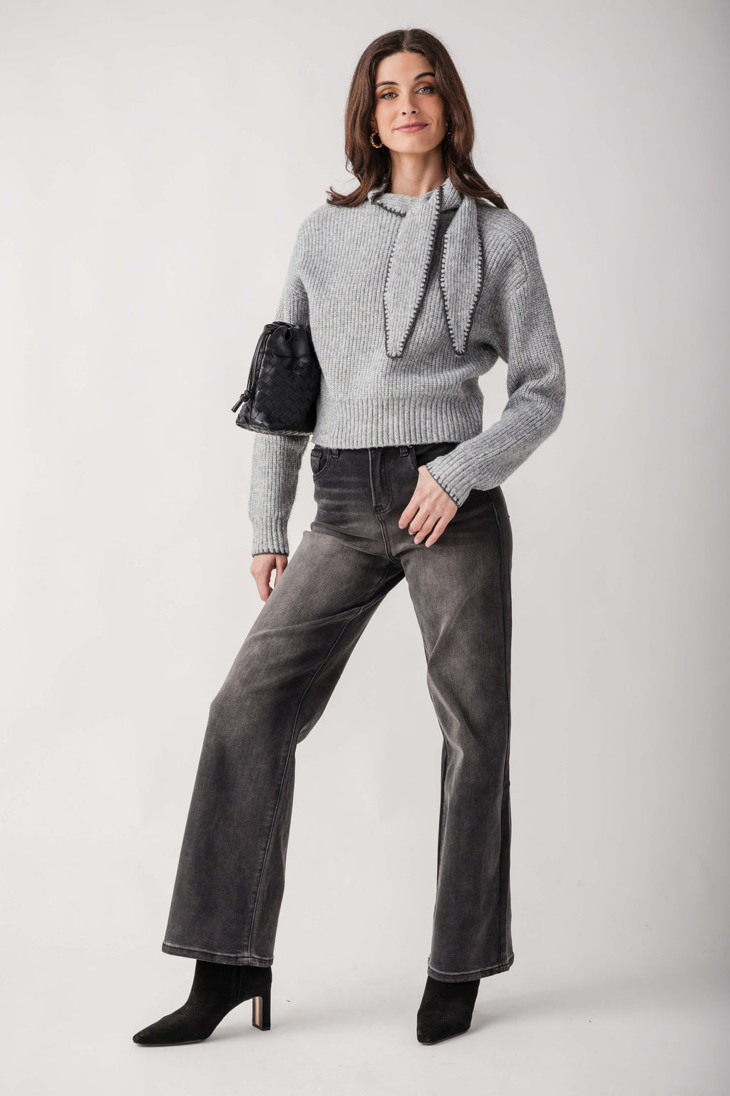 Woman wearing charcoal high-rise palazzo jeans with a gray ribbed sweater and black ankle boots.