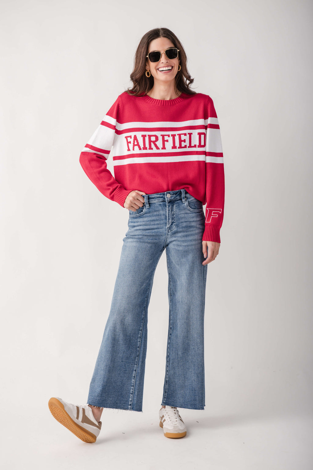 Red and white striped crew neck sweater with "Fairfield" text, paired with light blue cropped flare jeans.