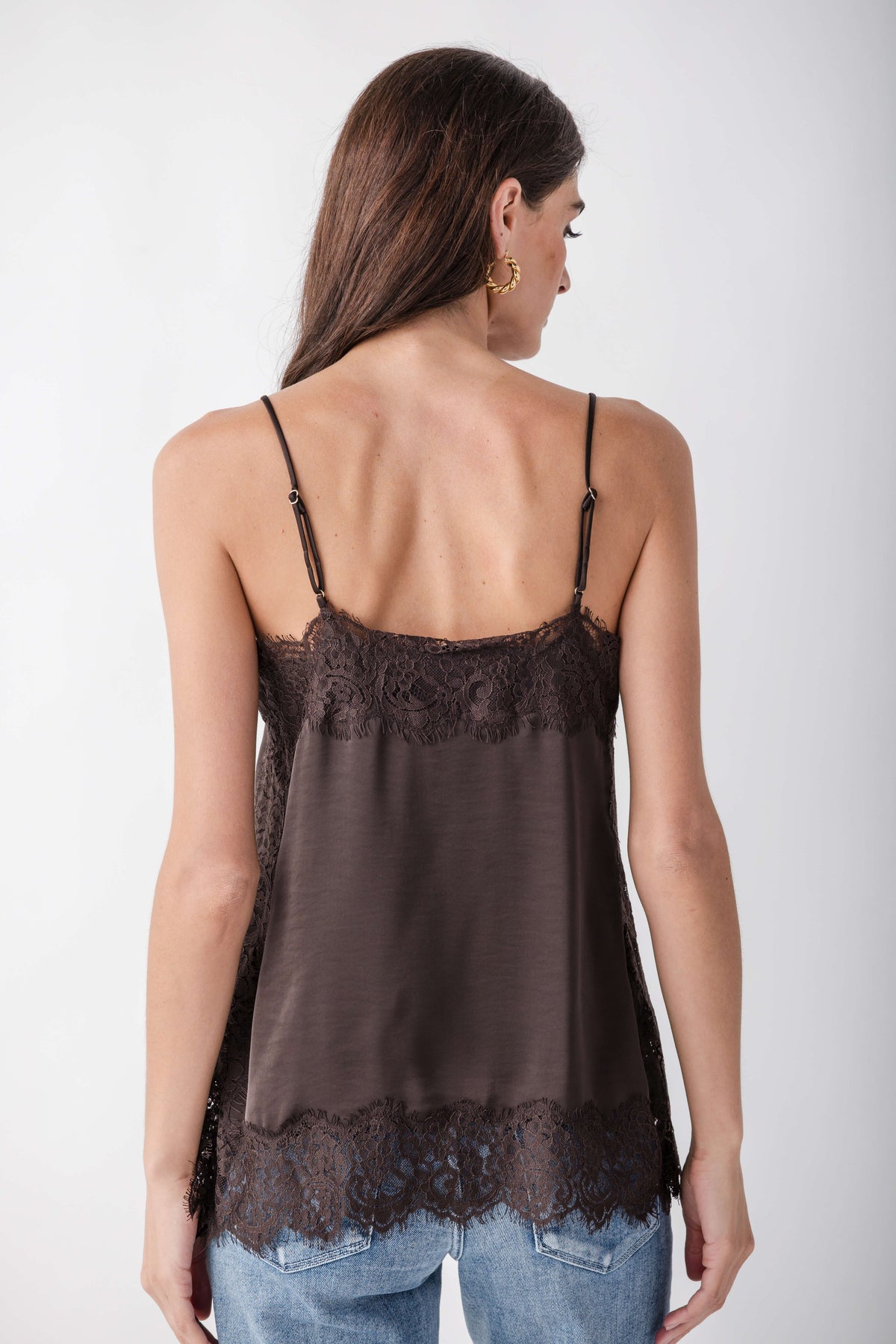 Charcoal lace cami with thin straps and lace trim on bodice and hem, worn over blue jeans.