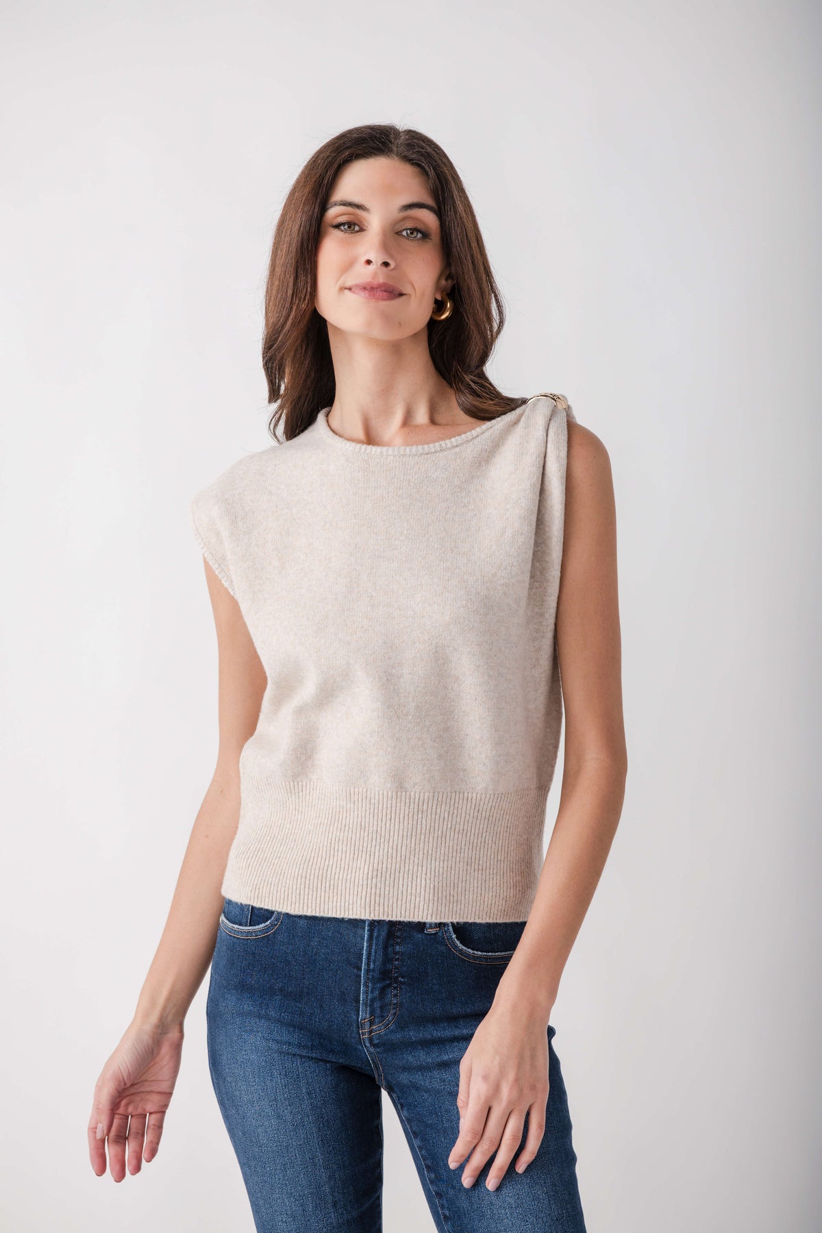 Cream sleeveless knit top with ruched shoulder detail, worn with blue jeans.