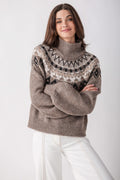 Gray turtleneck sweater with black and cream geometric pattern across chest and shoulders.