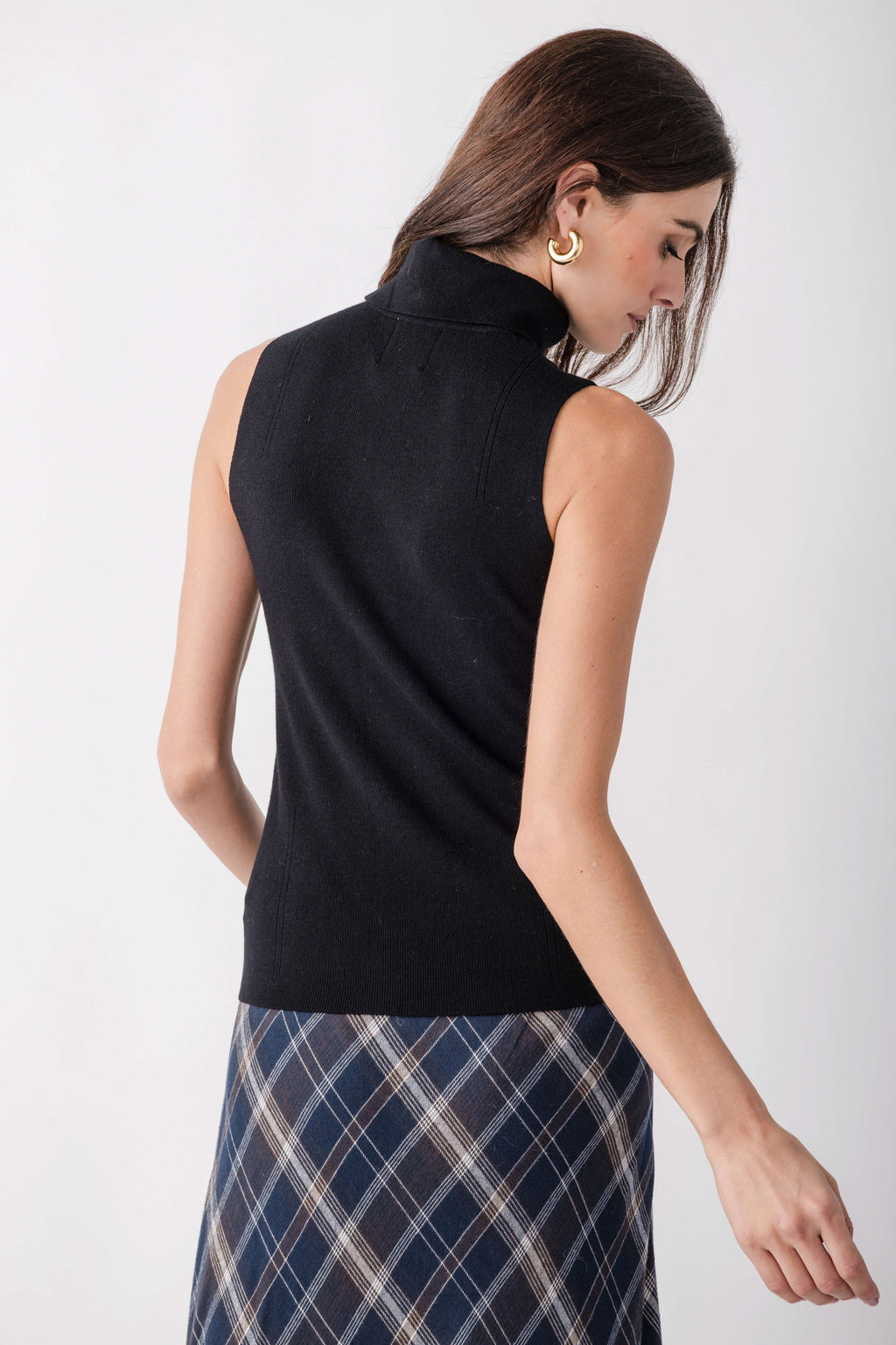 Black sleeveless mockneck top with ribbed texture, shown on model from back view.