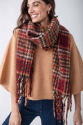 Red, cream, and black houndstooth scarf with fringe trim draped around woman's shoulders over tan sweater.