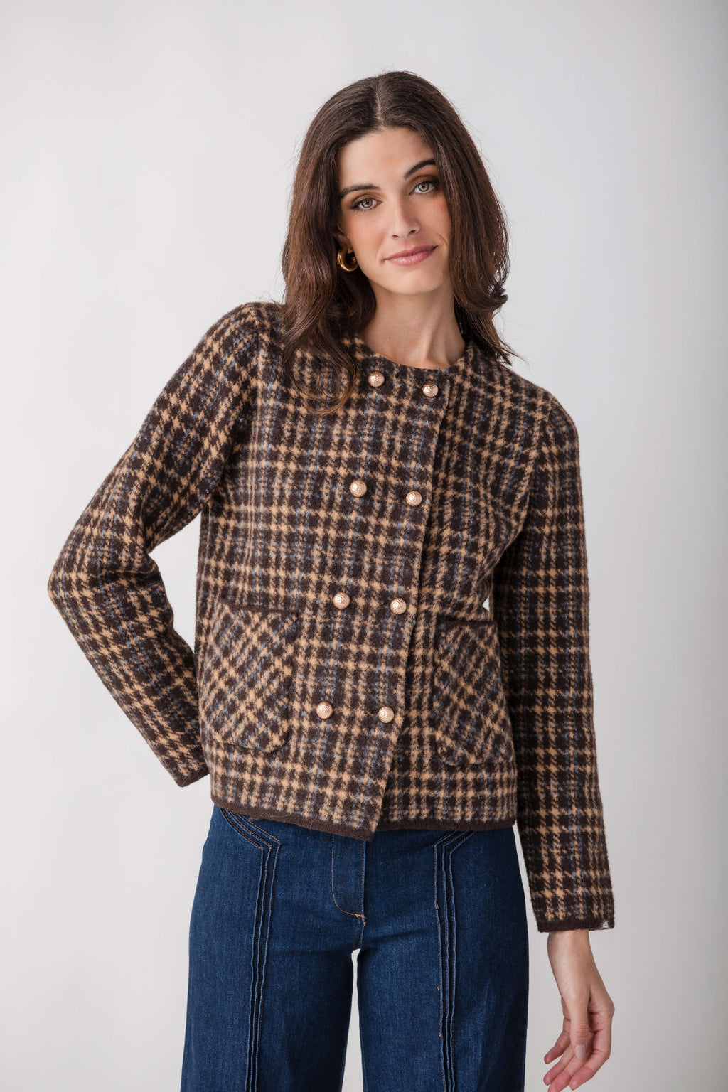 Brown and tan houndstooth tweed jacket with double-breasted pearl buttons and long sleeves.