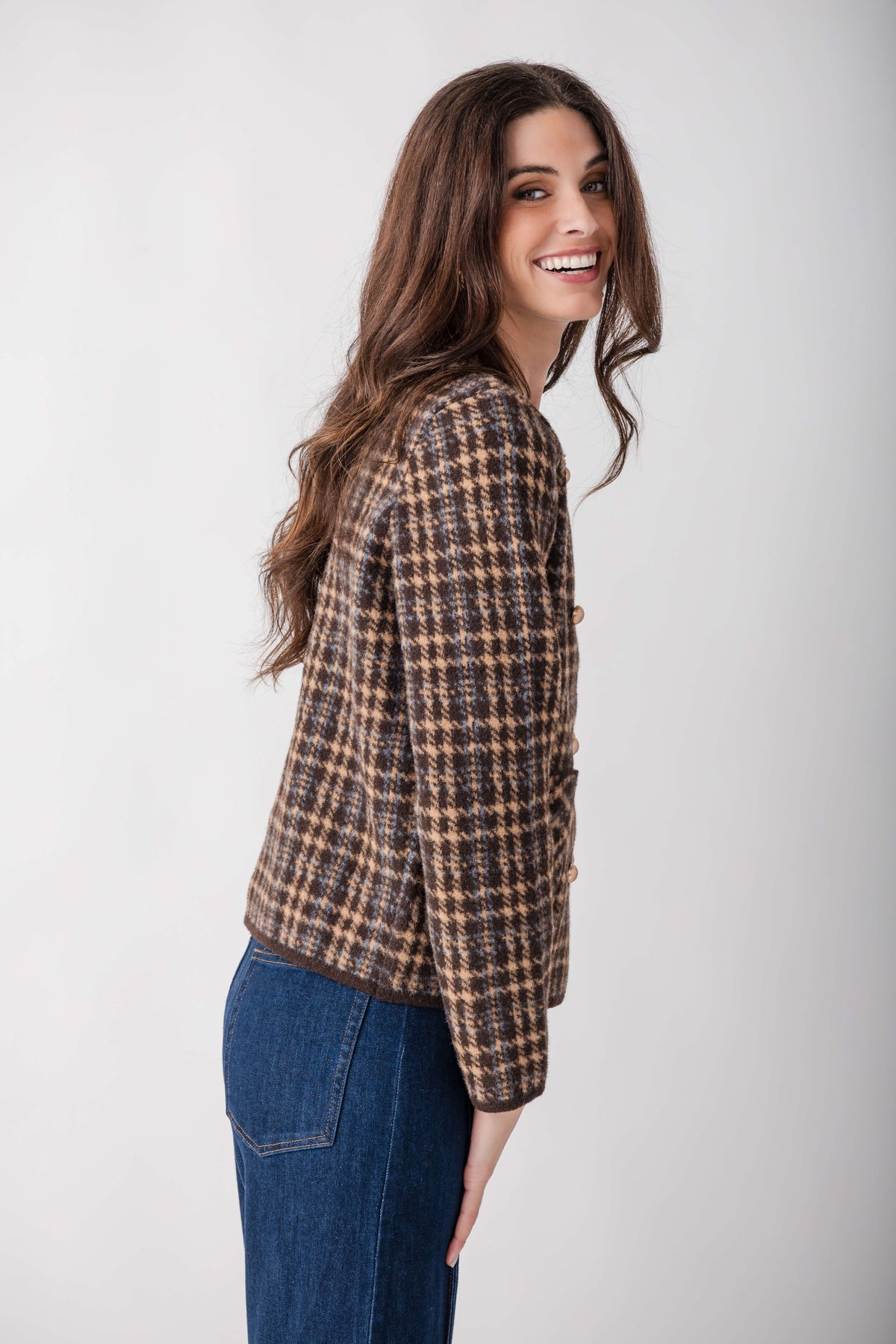 Brown and tan houndstooth tweed blazer with button front worn over blue jeans.