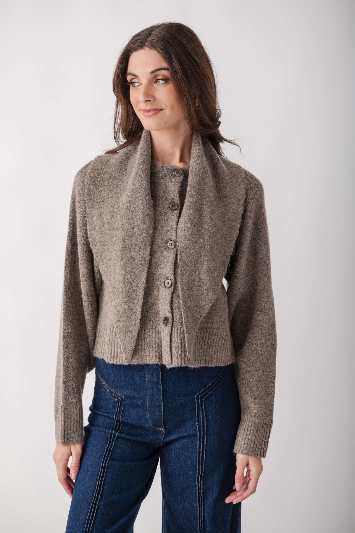 Taupe cardigan with detachable scarf collar and button front, worn with dark blue jeans.