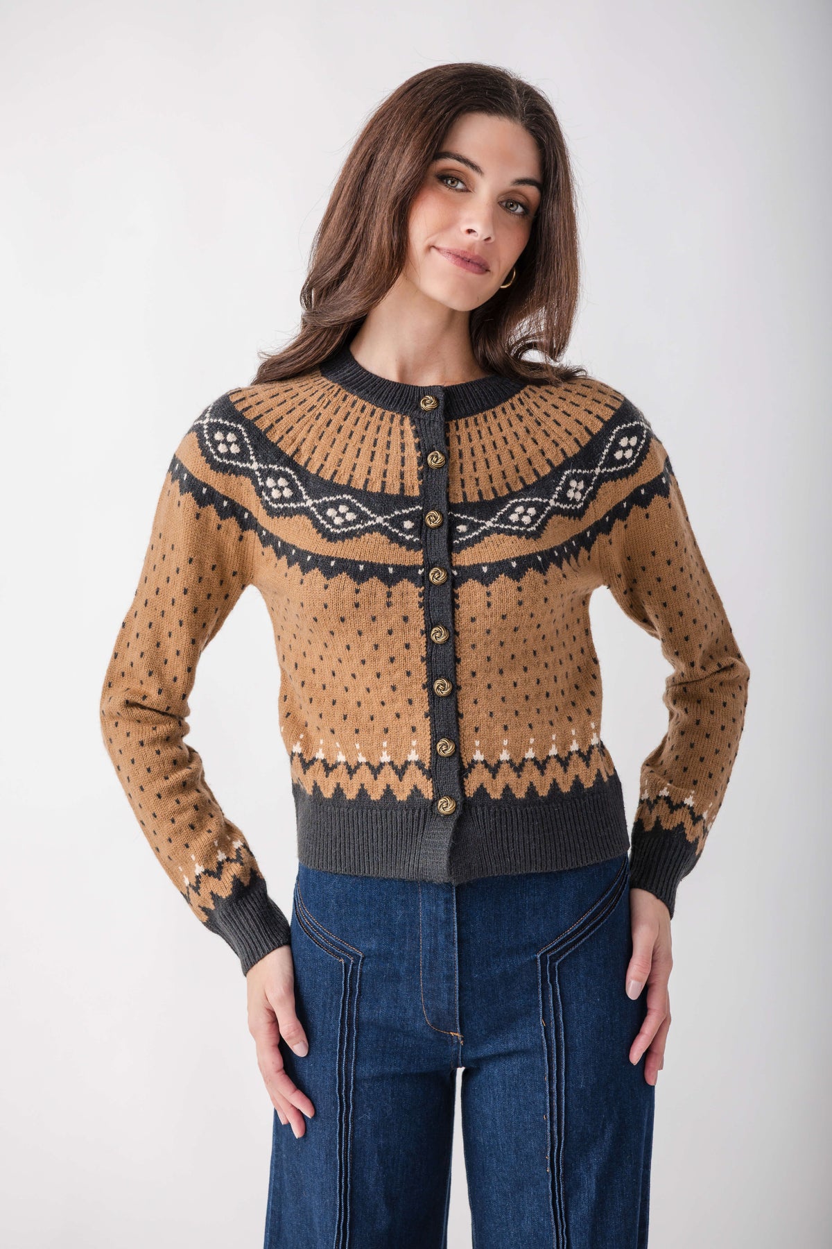 Tan and charcoal knit cardigan with geometric Fair Isle pattern and button front, styled with dark denim.