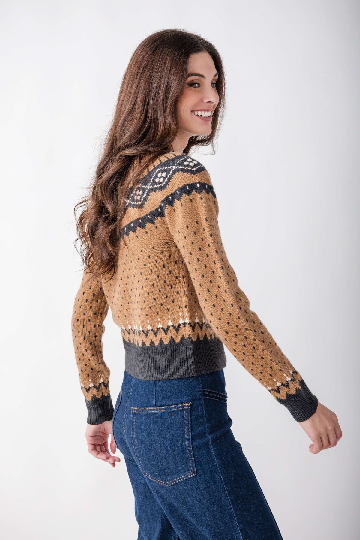 Tan cardigan with navy and cream geometric patterns across shoulders and sleeves, ribbed cuffs and hem.