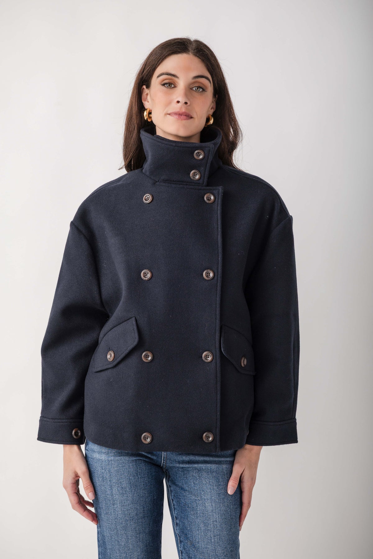 Navy wool double-breasted jacket with high collar, metal buttons, and patch pockets.