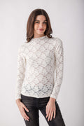 Cream lace long-sleeve mockneck top with scrollwork pattern worn with black jeans.