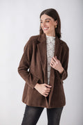 Brown corduroy blazer with notch lapels and button front, worn over white lace top.