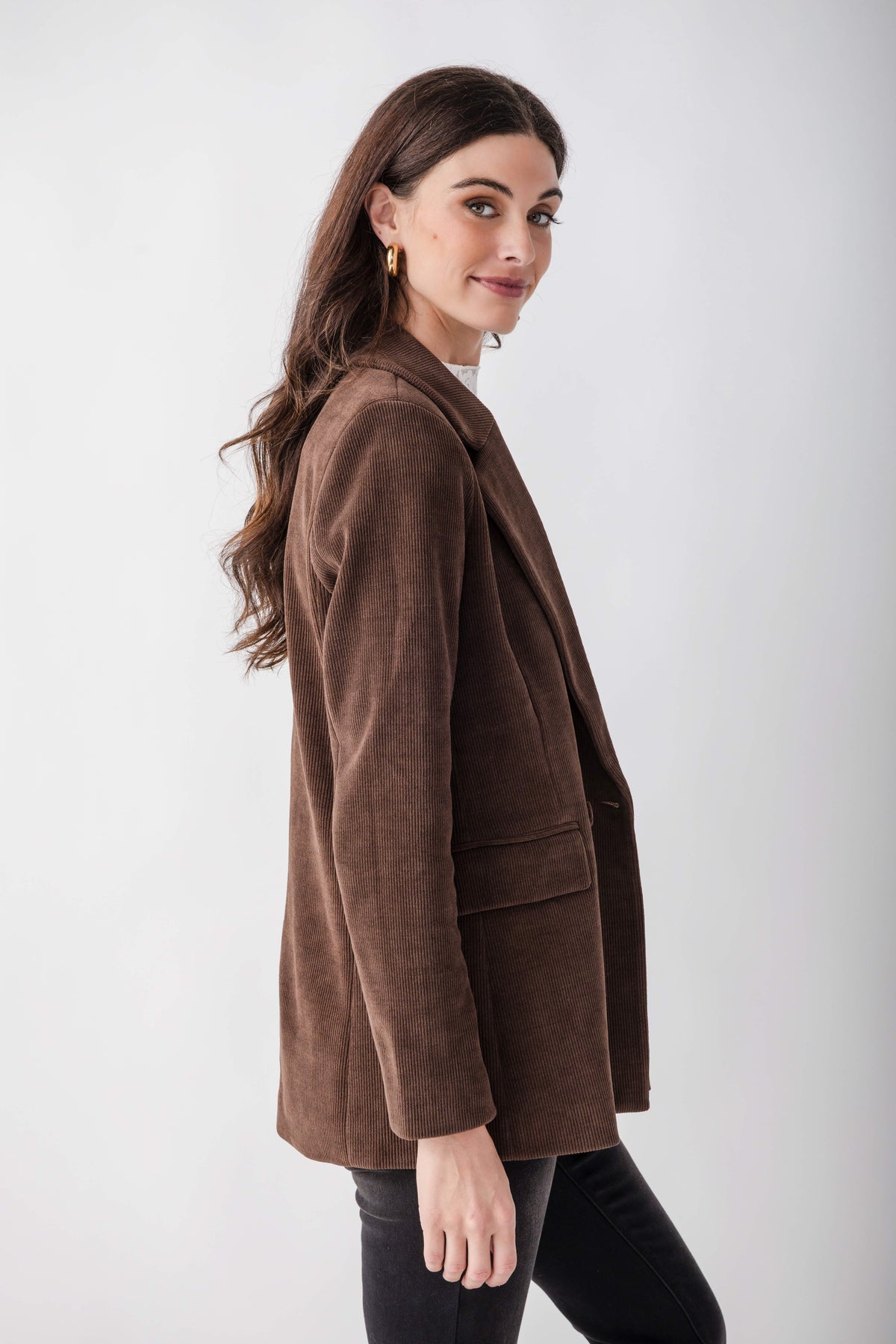 Brown corduroy blazer with notch lapels and chest pocket, worn over black pants.