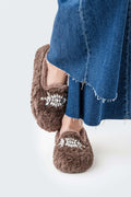 Brown plush loafer-style slipper with silver floral jewel embellishment on the toe.