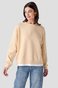 Light tan crewneck pullover with ribbed collar, cuffs, and hem
