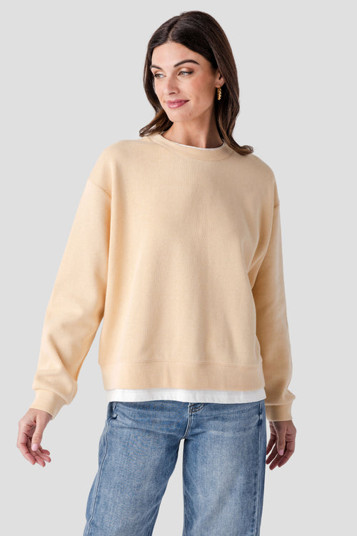 Light tan crewneck pullover with ribbed collar, cuffs, and hem