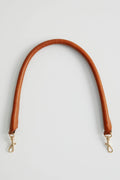 Brown tube strap with metal lobster clasps, curved ends for bag attachment